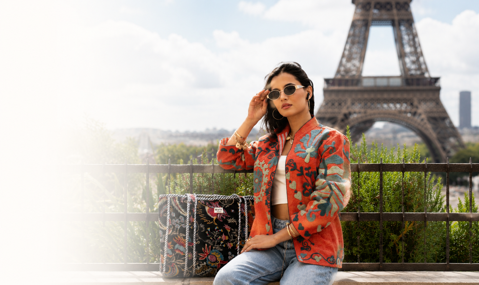 Woman in a colorful jacket sitting with the Eiffel Tower in the background