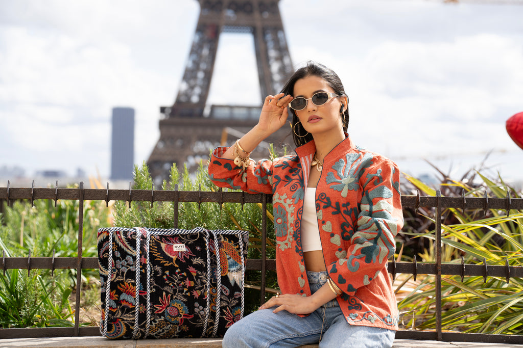 Celeste Tote - One Size - Suti Paris
Embroidered orange cotton jacket with floral patterns paired with a black floral cabas tote bag from SUTÎ Paris, photographed in front of the Eiffel Tower.
Veste orange en coton brodé à motifs floraux et cabas noir à motifs floraux de SUTÎ Paris, photographiés devant la tour Eiffel.