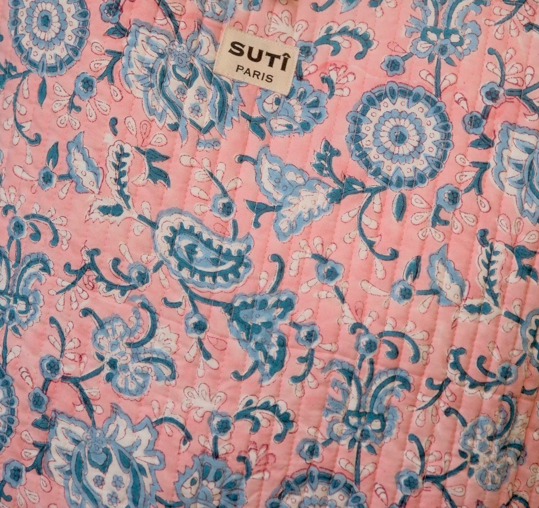 Fabric with blue floral pattern on pink background, featuring SUTi Paris label.